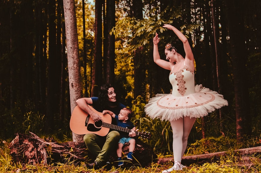 picture of a man  with a guitar, little boy and girl in beautiful ballerina tutu in the forest 