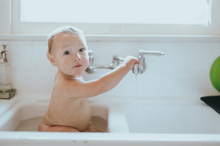 picture of a baby taking a bath in the sink