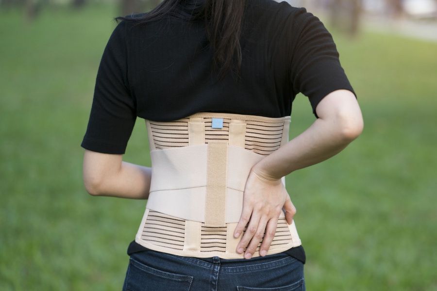 woman in nature captured from her back wearing back brace