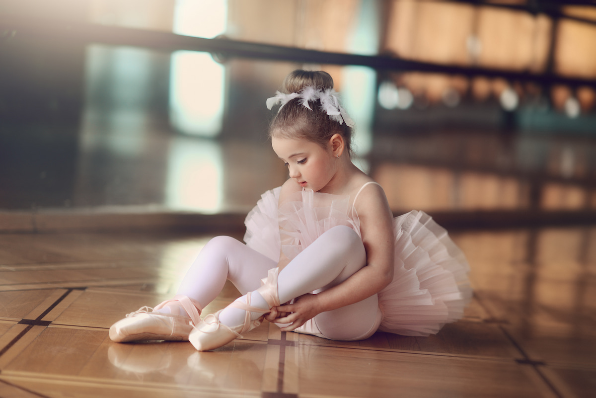 little ballerina tighting her pointe shoes