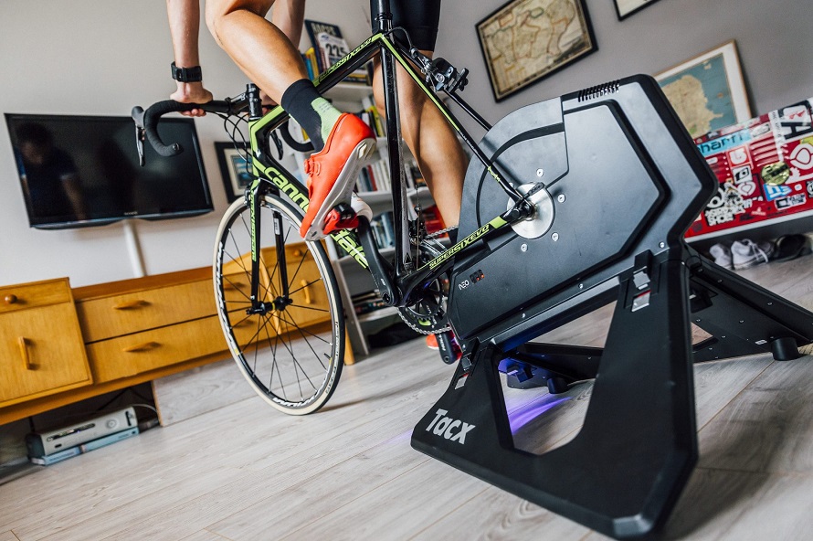 man riding with an indoor turbo trainer in living room close up