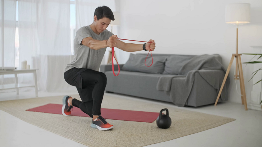 man exercising with a resistance band in living room 