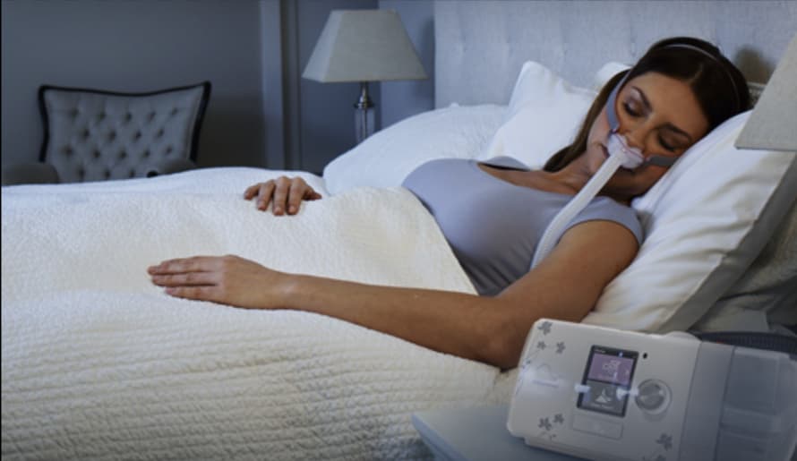 woman sleeping with an AirSense 10 CPAP machine