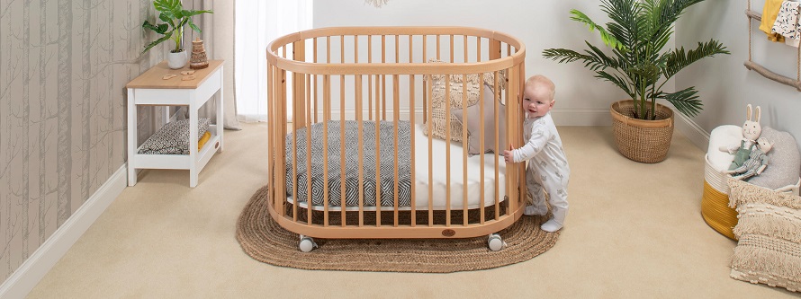 picture of a baby holding to a baby cot
