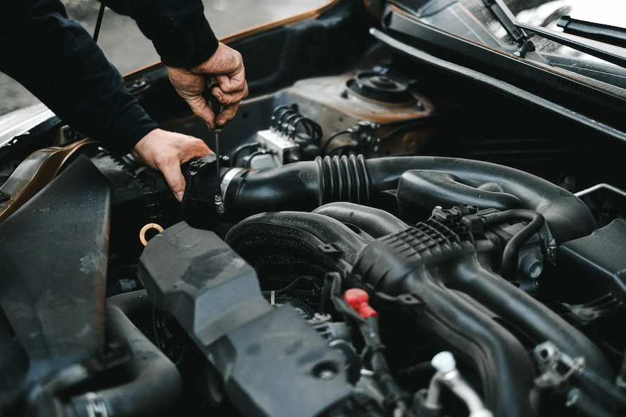 man fixing his cars cold air intake system