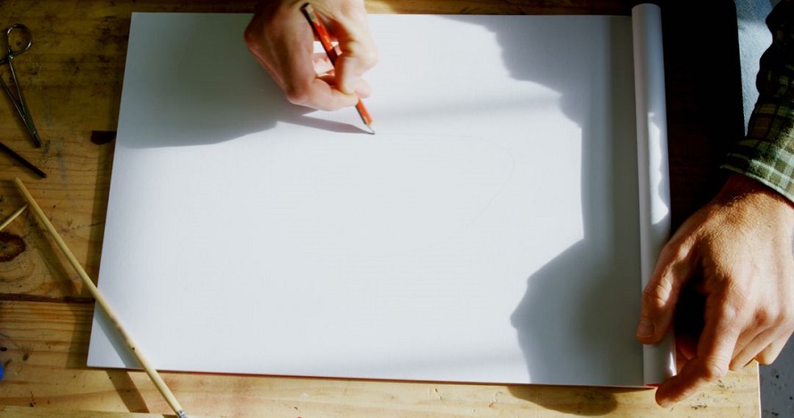man starting to draw on a blank paper