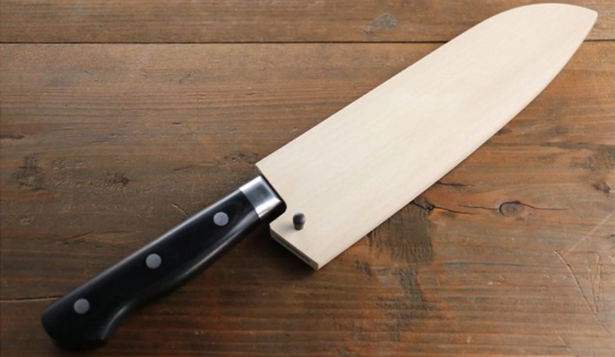 knife with a knife sheath on a wooden desk 