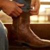 man putting on his Ariat boots