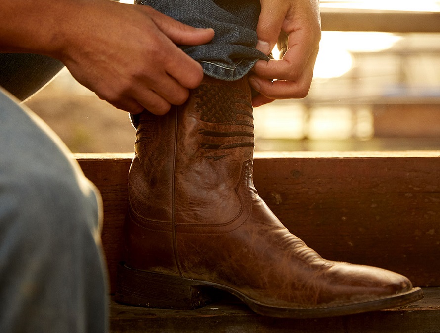 man putting on his Ariat boots