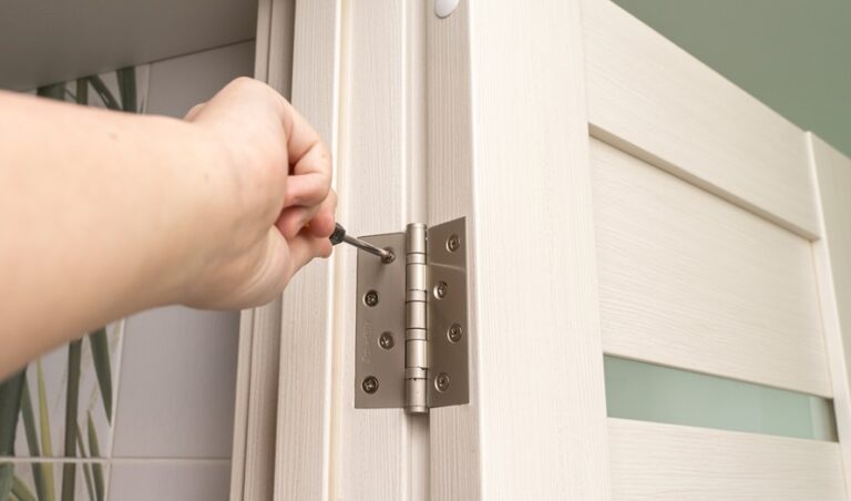 person using a screwdriver to fasten a hinge butt