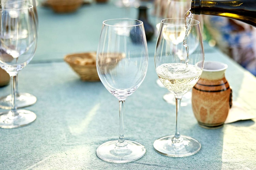 a person fills glasses with Riesling wine